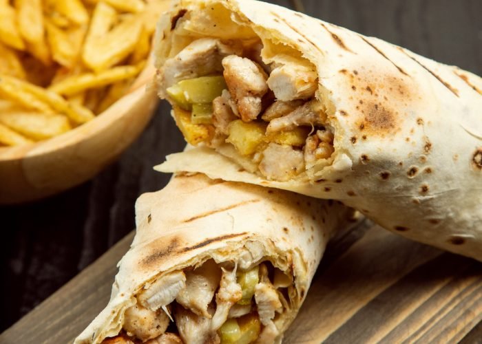 Chicken durum, shaurma with lavash and french fries on wooden board. image